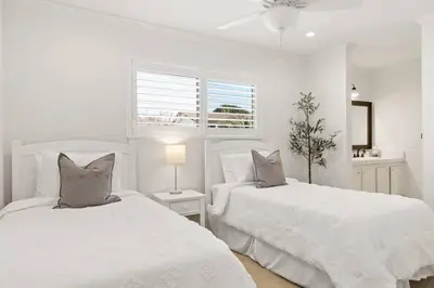 a white bedroom with two beds and a window at Goode HOMES Stunning Home w/ Beautiful Backyard in Santa Clarita