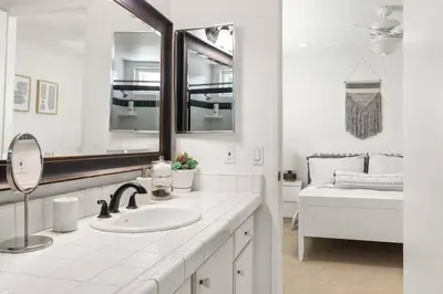 a bathroom with a sink and a mirror and a bed at Goode HOMES Stunning Home w/ Beautiful Backyard in Santa Clarita