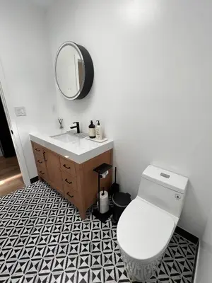 a bathroom with a white toilet and a mirror at Newly Built Private Guest House in Glendale