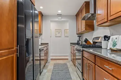 a kitchen with wooden cabinets and a black refrigerator at Luxury home w/ yard + parking in Newhall