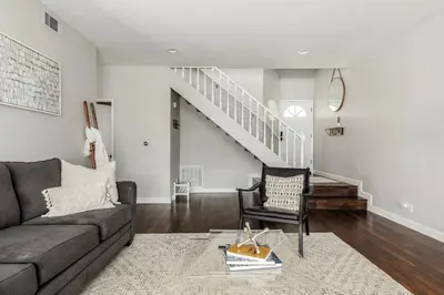 a living room with a couch and a staircase at Luxury Modern Home w/ Jacuzzi | GOODE HOMES in Santa Clarita