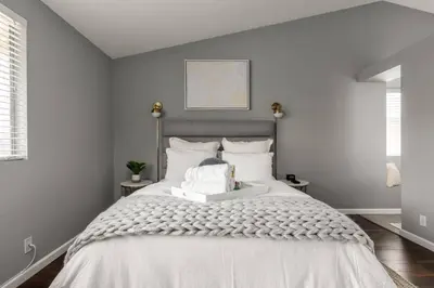 a bedroom with a large bed with white sheets at Luxury Modern Home w/ Jacuzzi | GOODE HOMES in Santa Clarita