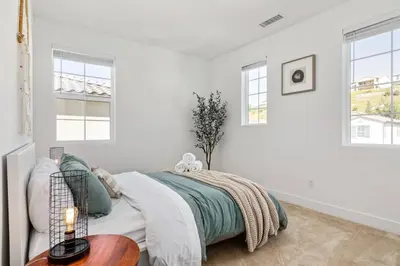 a white bedroom with a bed and a table at Luxury Mountain View Home w/ large backyard in Santa Clarita