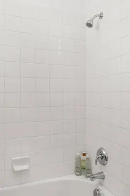 a white tiled bathroom with a tub and a shower at Luxury Mountain View Home w/ large backyard in Santa Clarita