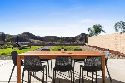 a wooden table and chairs with mountains in the background at Scenic Mountain View Home with Spacious Yard in Santa Clarita