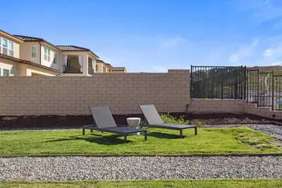 two chairs and a table sitting on the grass at Scenic Mountain View Home with Spacious Yard in Santa Clarita