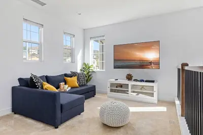 a living room with a blue couch and a tv at Scenic Mountain View Home with Spacious Yard in Santa Clarita