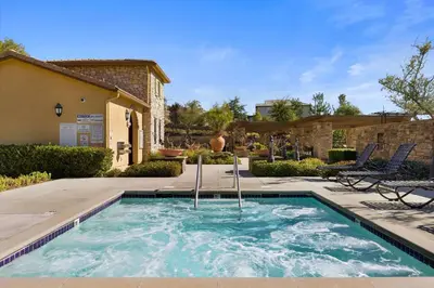 a swimming pool in a yard with chairs and a building at Scenic Mountain View Home with Spacious Yard in Santa Clarita