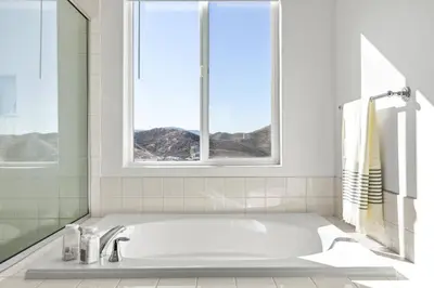 a white bathroom with a tub and a window at Scenic Mountain View Home with Spacious Yard in Santa Clarita