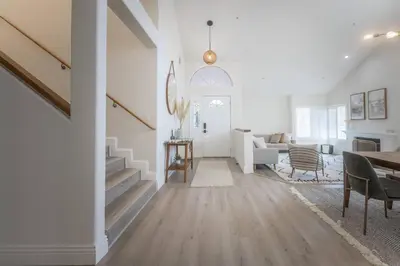 a living room with a staircase and a dining room at Goode.Homes Hilltop Home w. private pool/spa in Newhall