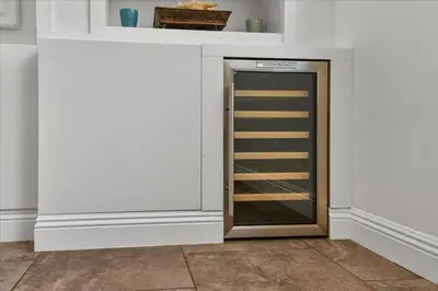 a cabinet with a glass door in a room at GOODE.HOMES | Luxury Home w/ pool & lush gardens in Santa Clarita