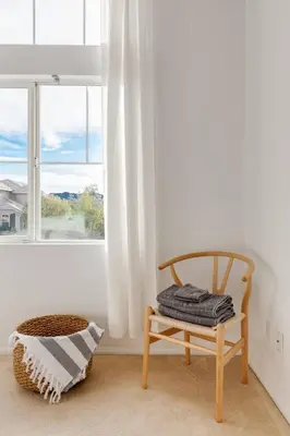 a chair sitting in a room with a window at GOODE.HOMES | Luxury Home w/ pool & lush gardens in Santa Clarita