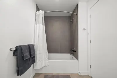a bathroom with a tub and a shower with a shower curtain at Stylish City Escape Walk to Shops Dine & Explore in Long Beach