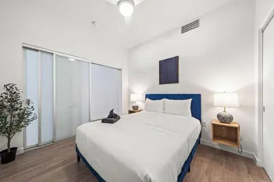 a bedroom with a large bed with a blue headboard at Stylish City Escape Walk to Shops Dine & Explore in Long Beach