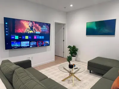 a living room with a couch and a flat screen tv at Luxury 2BD 2BA with Roof Top Pool, Hot Tub & Gym in Los Angeles