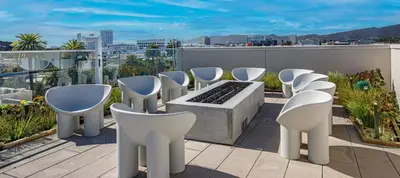 a group of white chairs sitting on a roof at Luxury 2BD 2BA with Roof Top Pool, Hot Tub & Gym in Los Angeles