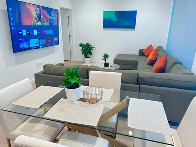 a living room with a glass table and a couch at Luxury 2BD 2BA with Roof Top Pool, Hot Tub & Gym in Los Angeles