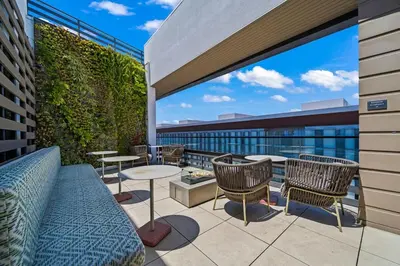 a patio with tables and chairs on a building at Chic Downtown Stay Walk to Beach in Long Beach