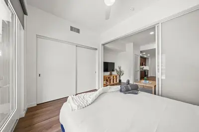 a bedroom with a white bed and a large mirror at Chic Downtown Stay Walk to Beach in Long Beach