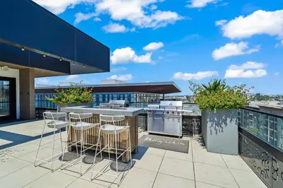 a patio with bar stools and a kitchen on a building at Chic Downtown Stay Walk to Beach in Long Beach