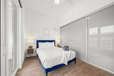 a bedroom with a blue and white bed and a tub at Top-Floor Gem & Heated Pool Walk to Attractions in Long Beach