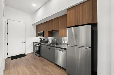 a kitchen with stainless steel appliances and wooden cabinets at Top-Floor Gem & Heated Pool Walk to Attractions in Long Beach