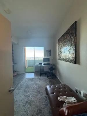 a living room with a couch and a desk with a computer at Aqua Towers in Long Beach
