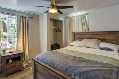 a bedroom with a bed and a ceiling fan at Cozy Forest Cottage w Lake Glimpse and Grill in Fawnskin