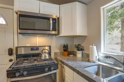 a kitchen with a stove and a microwave at Cozy Forest Cottage w Lake Glimpse and Grill in Fawnskin