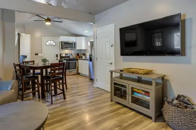 a living room with a kitchen and a dining room at Cozy Forest Cottage w Lake Glimpse and Grill in Fawnskin