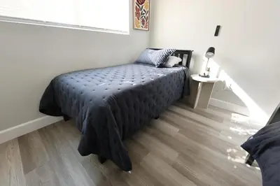 a bedroom with a bed with a black comforter at Family Friendly Southwest Bakersfield Retreat with Jacuzzi and Fenced Yard in Bakersfield
