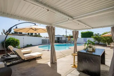 a patio with a pool and a white pergola at Dream Dip - Heater Pool and Spa - Clost to Disney in Placentia