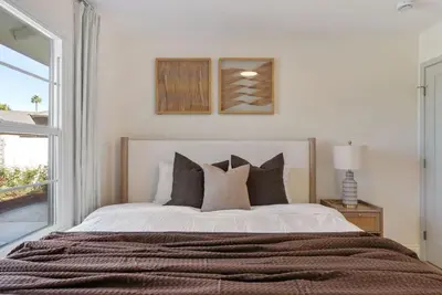 a bedroom with a bed with pillows and a window at Dream Dip - Heater Pool and Spa - Clost to Disney in Placentia