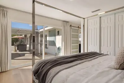 a bedroom with a large bed and a sliding glass door at Dream Dip - Heater Pool and Spa - Clost to Disney in Placentia
