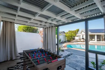 a poolside foosball table in a room with a pool and a patio at Dream Dip - Heater Pool and Spa - Clost to Disney in Placentia