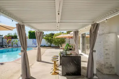 a patio with a table and chairs next to a pool at Dream Dip - Heater Pool and Spa - Clost to Disney in Placentia