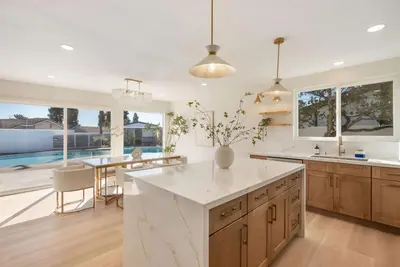 a kitchen with a large white counter top and a table at Dream Dip - Heater Pool and Spa - Clost to Disney in Placentia
