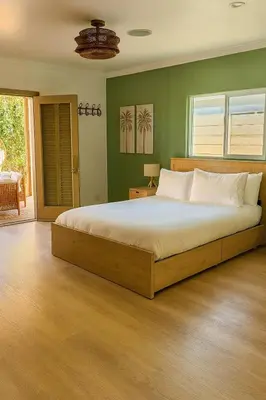 a bedroom with a large bed with green walls at WeHo Pool Retreat - Holiday Ready in Los Angeles