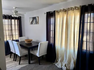 a dining room with a black table and white chairs at Unique apartment in Los Angeles