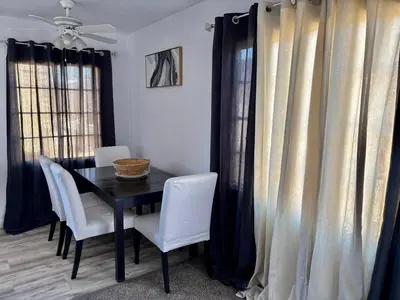 a dining room with a black table and white chairs at Unique apartment in Los Angeles