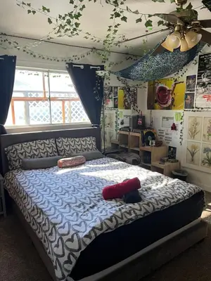 a bedroom with a bed with a blue and white comforter at Cozy Artistic Teen Room, Fun & Full of Personality in Bodfish
