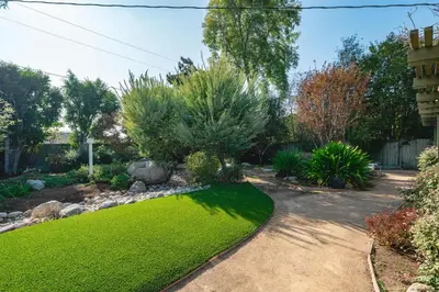 a garden with green grass and bushes at Airy Large Backyard Oasis Perfect Family Getaway in Tustin