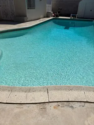 a swimming pool with blue water in a building at Magnolia Pool Cottage Home in Lynwood