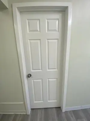 a white door in a room with a wooden floor at Magnolia Pool Cottage Home in Lynwood