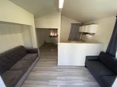 a living room with two couches and a kitchen at Magnolia Pool Cottage Home in Lynwood
