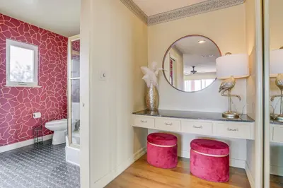 a bathroom with a mirror and pink stools at Stunning MCM Escape with Mtn Views in San Bernardino in San Bernardino