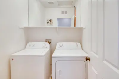 a laundry room with two whitewashes and a washer and dryer at Home Theater System and Gazebo Los Angeles Getaway! in San Fernando