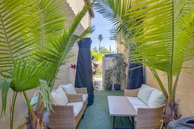 a patio with chairs and a table and palm trees at Home Theater System and Gazebo Los Angeles Getaway! in San Fernando