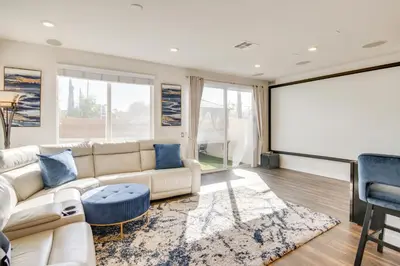a living room with a white couch and a large screen at Home Theater System and Gazebo Los Angeles Getaway! in San Fernando