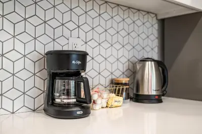 a black coffee maker on a counter in a kitchen at Newly Remodeled 3BR Apt | Mins to Disney | Arcade in Placentia